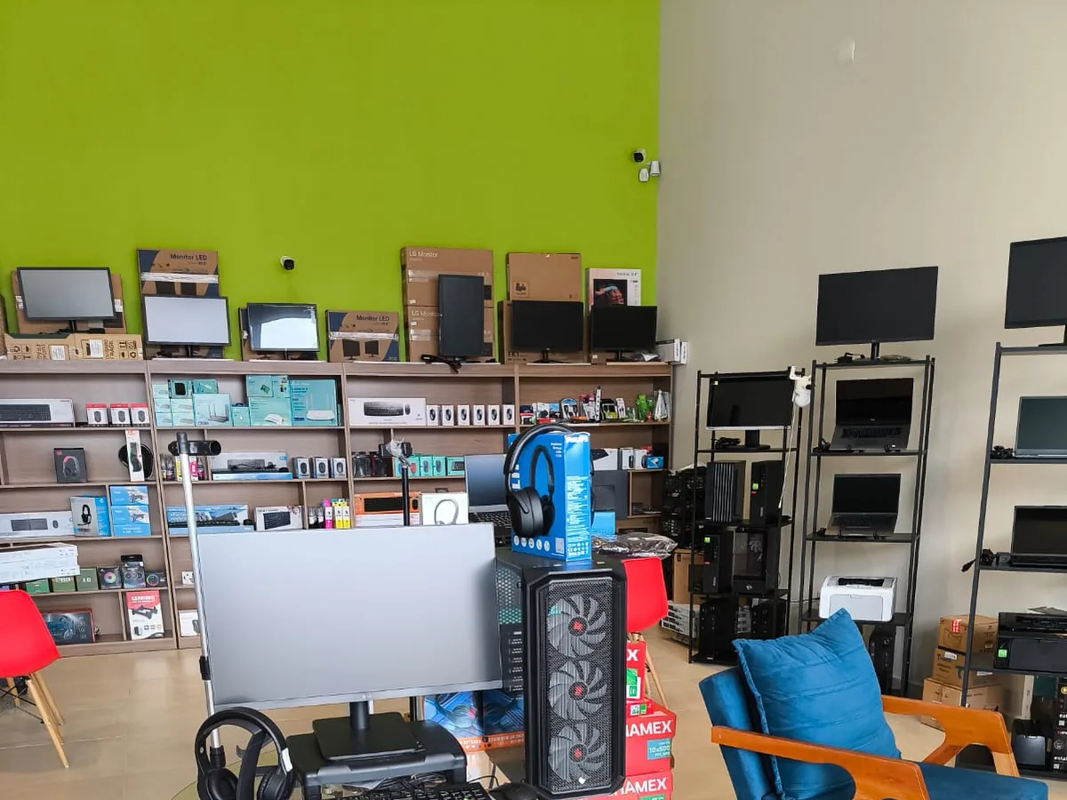 Monitores, computador, headset e equipamentos expostos na Plioou